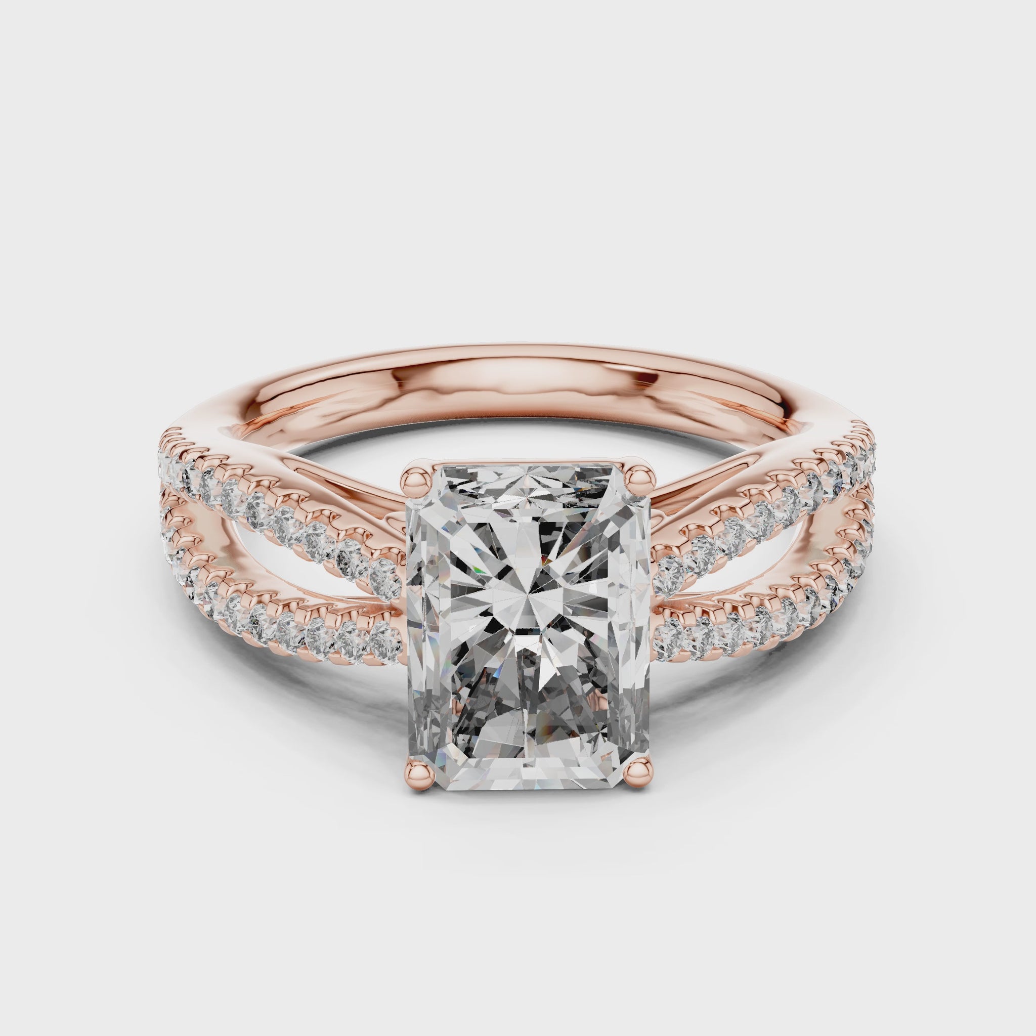 Rose gold ring with a large diamond and smaller diamonds on the band against a white background is rotating on a white surface.