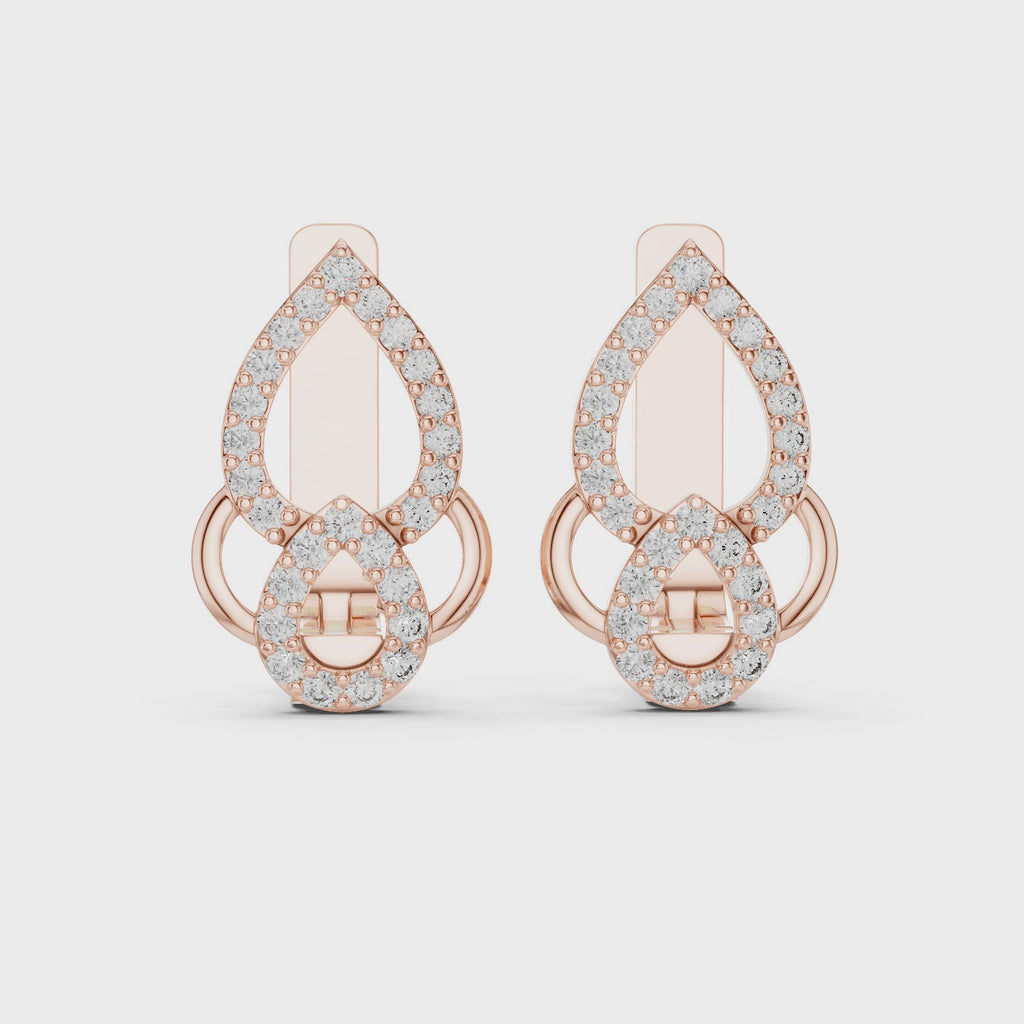 Rose gold earrings with clear diamonds is rotating horizontally on a white surface.