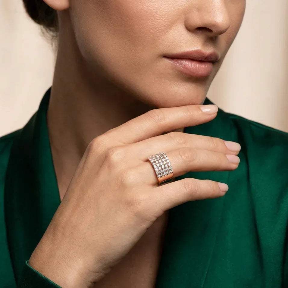 Close-up of a woman's hand wearing a real diamond ring on a neutral background