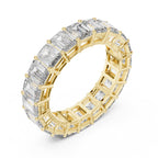 Yellow gold ring with emerald-cut natural diamonds on a white background
