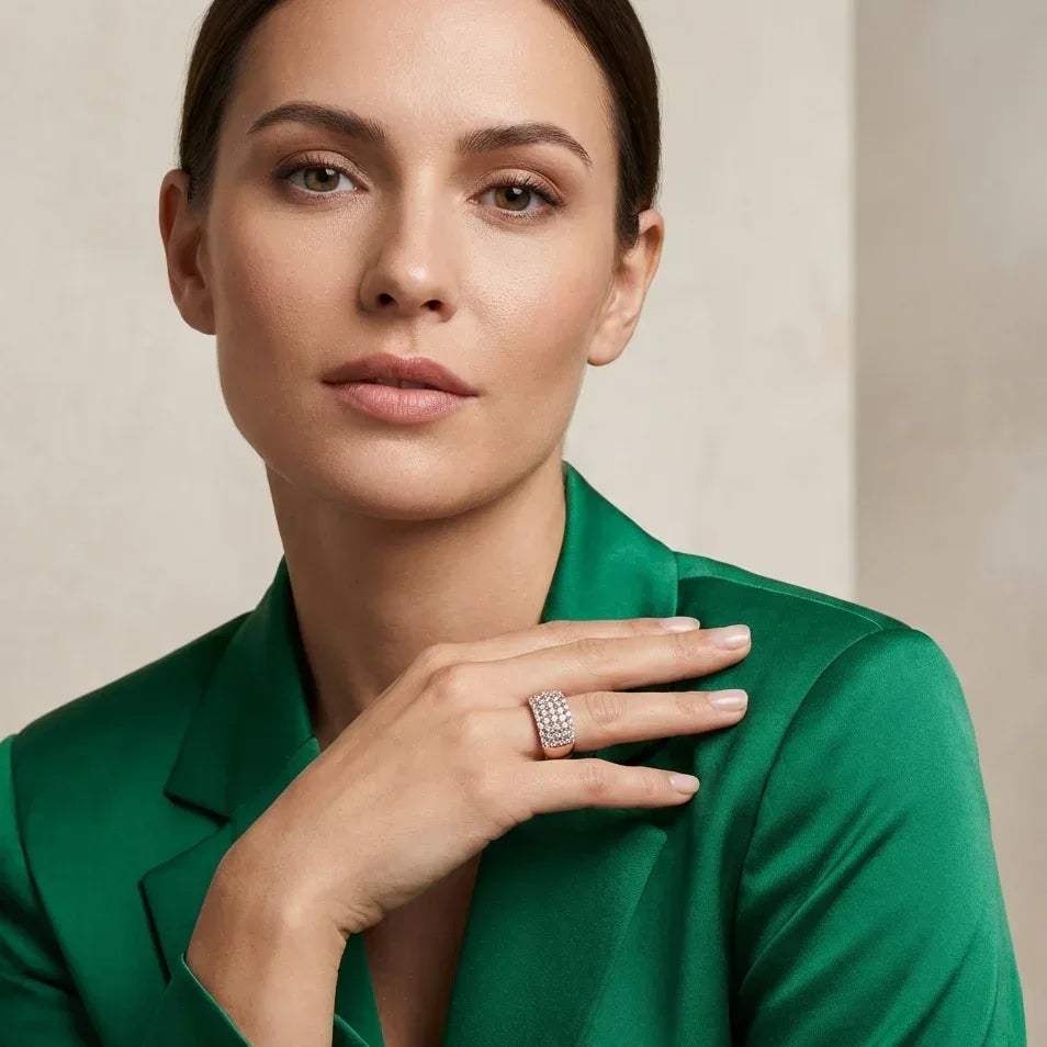 Woman wearing a green jacket and a lab grown diamond band ring with a beige background