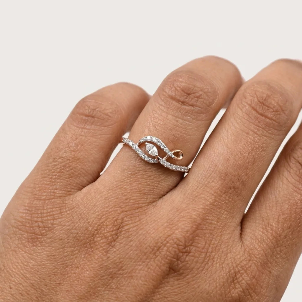 A close-up of a hand wearing a gold ring with a round diamonds and small pavé accents.