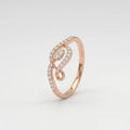 A rose gold ring with a curved, openwork design paved with small clear stones, shown on a light gray gradient background.