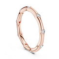 Rose gold ring with embedded diamonds on a white background