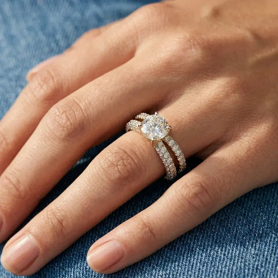 Close-up of a hand wearing a diamond ring on a blue fabric background