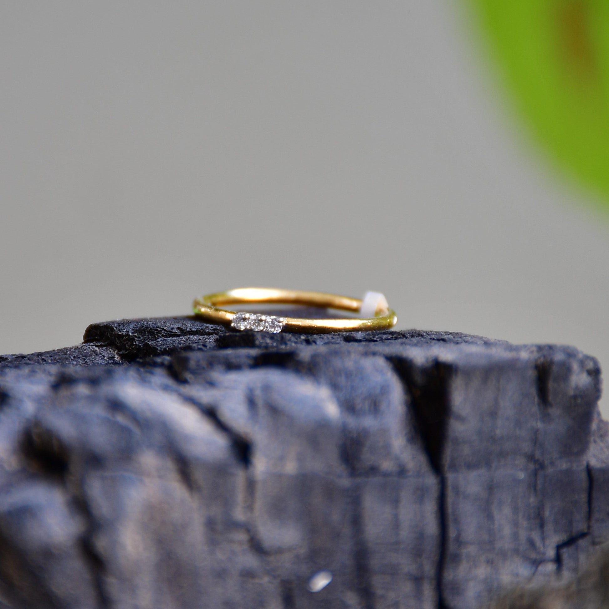 A diamond band ring on a textured rough surface.