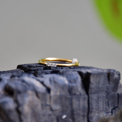 A diamond band ring on a textured rough surface.