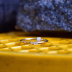 A diamond band ring on a yellow textured surface.