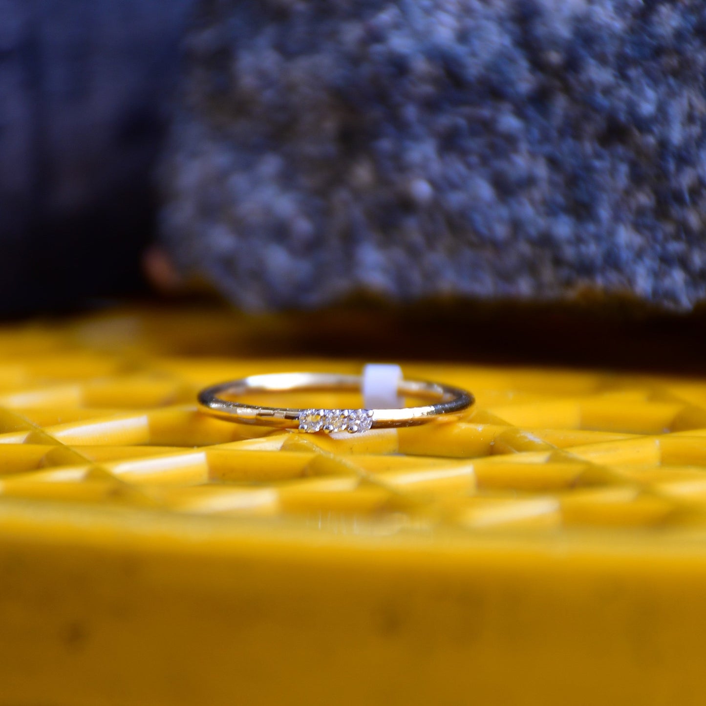 A diamond band ring on a yellow textured surface.