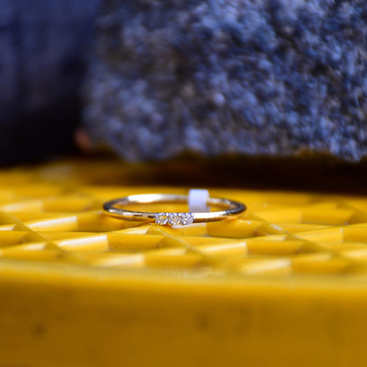 A diamond band ring on a yellow textured surface.