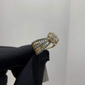 Elegant gold diamond ring featuring a round-cut central diamond surrounded by a halo of smaller diamonds, set on a split shank band adorned with rows of sparkling pavé diamonds, displayed on a black gloved hand against a neutral background.