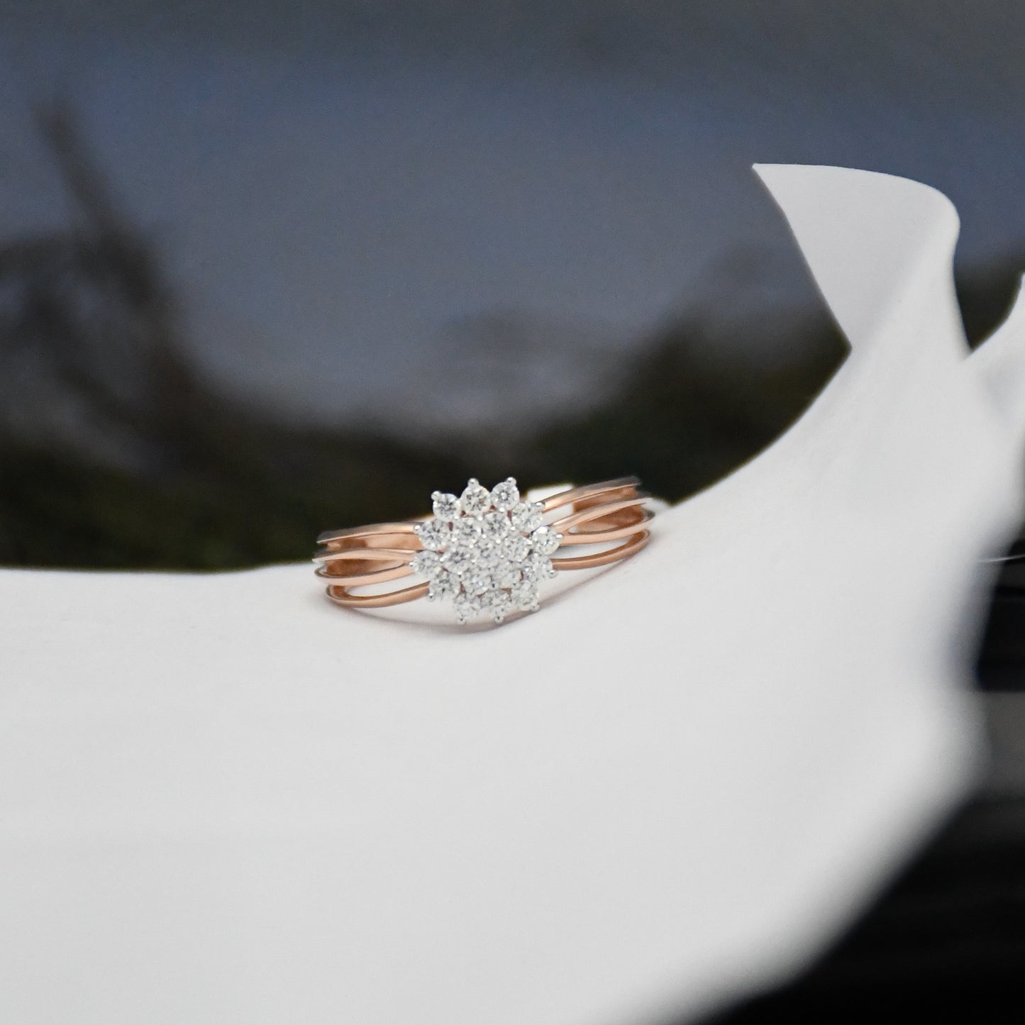 Rose gold ring with diamonds on a white surface