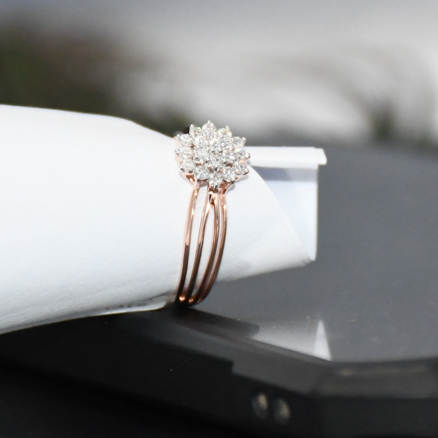 Rose gold ring with diamonds on a white surface