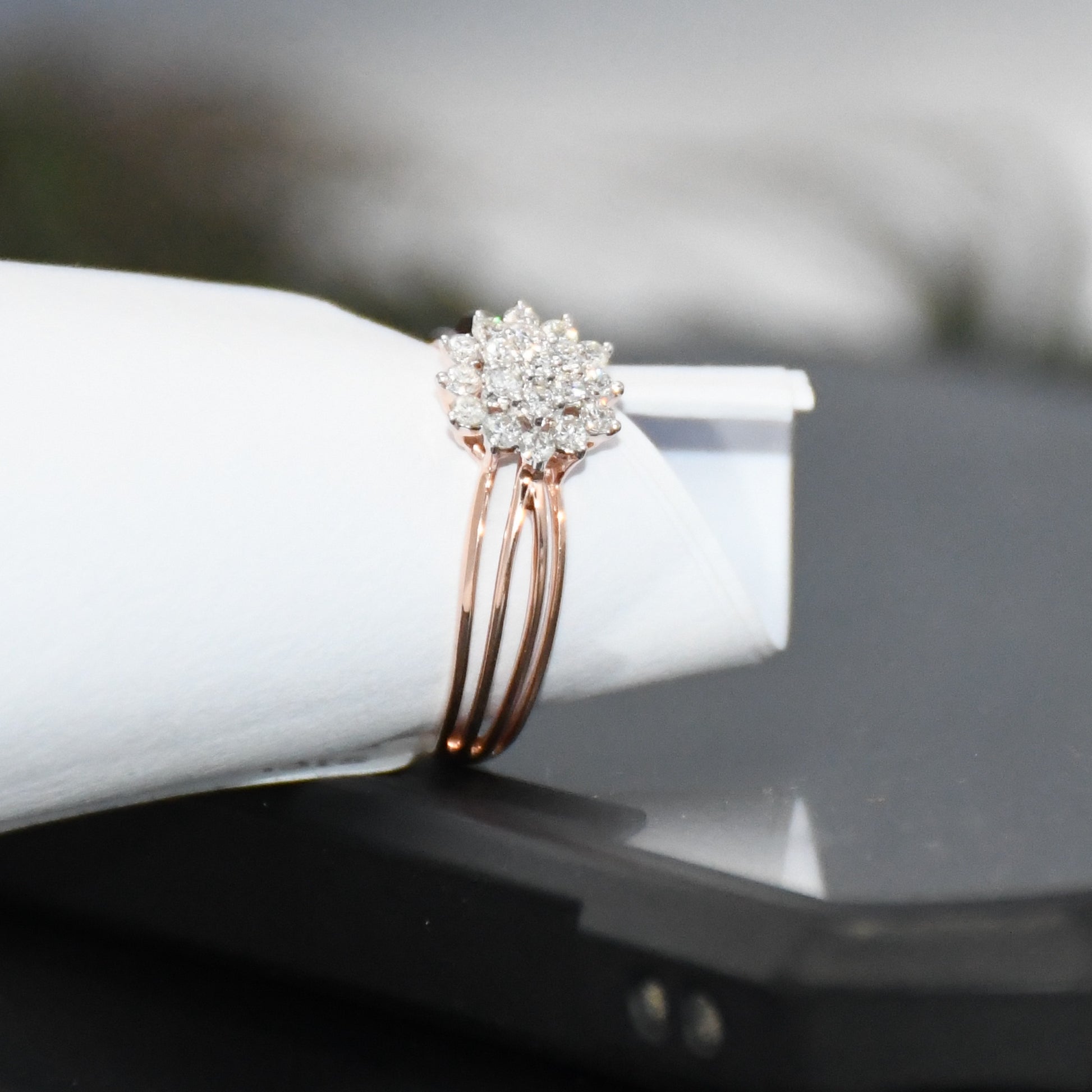 Rose gold ring with diamonds on a white surface