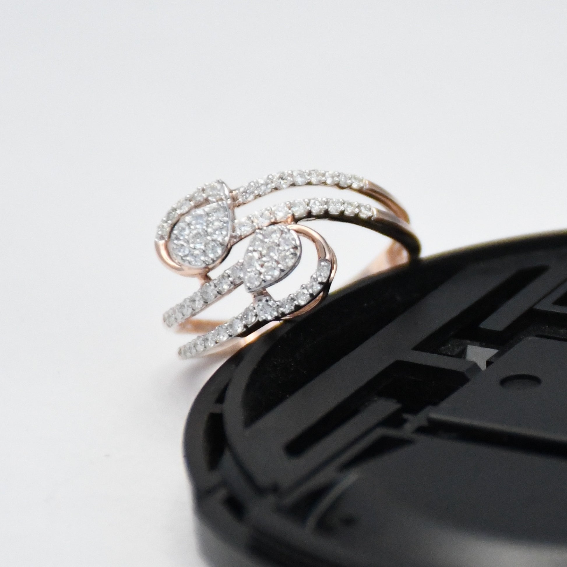 gold ring with diamonds on a black phone case against a white background