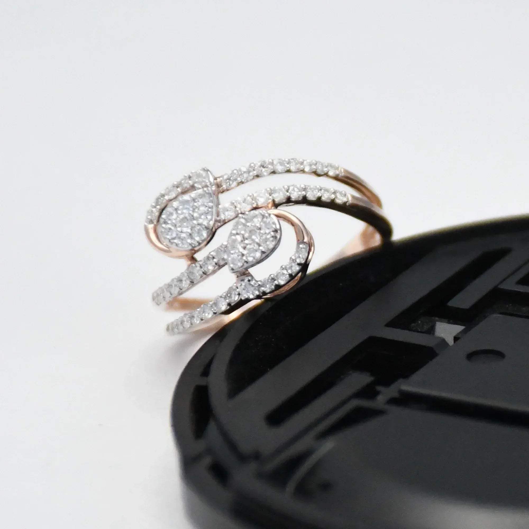 gold ring with diamonds on a black phone case against a white background
