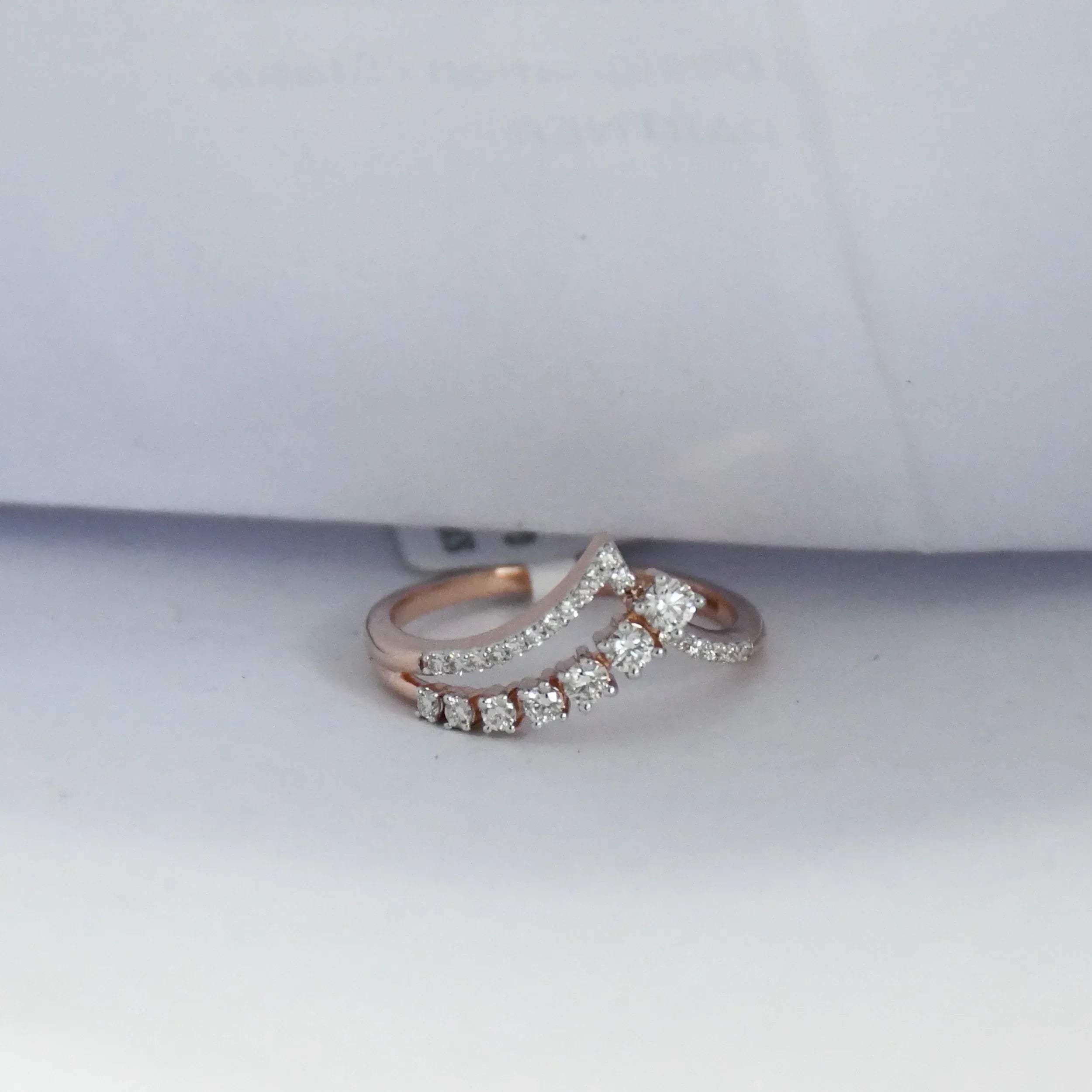 Rose gold ring with diamonds on a white background