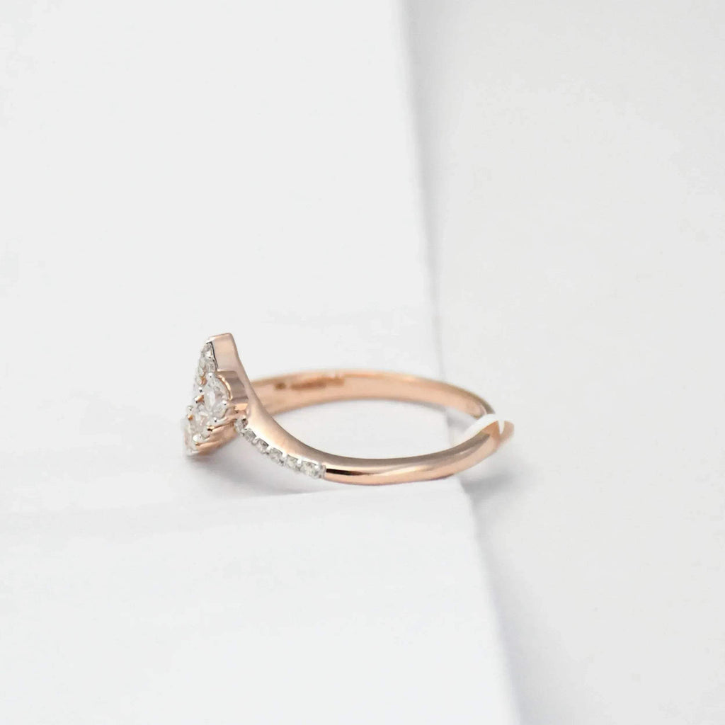 Rose gold ring with diamonds on a light gray background