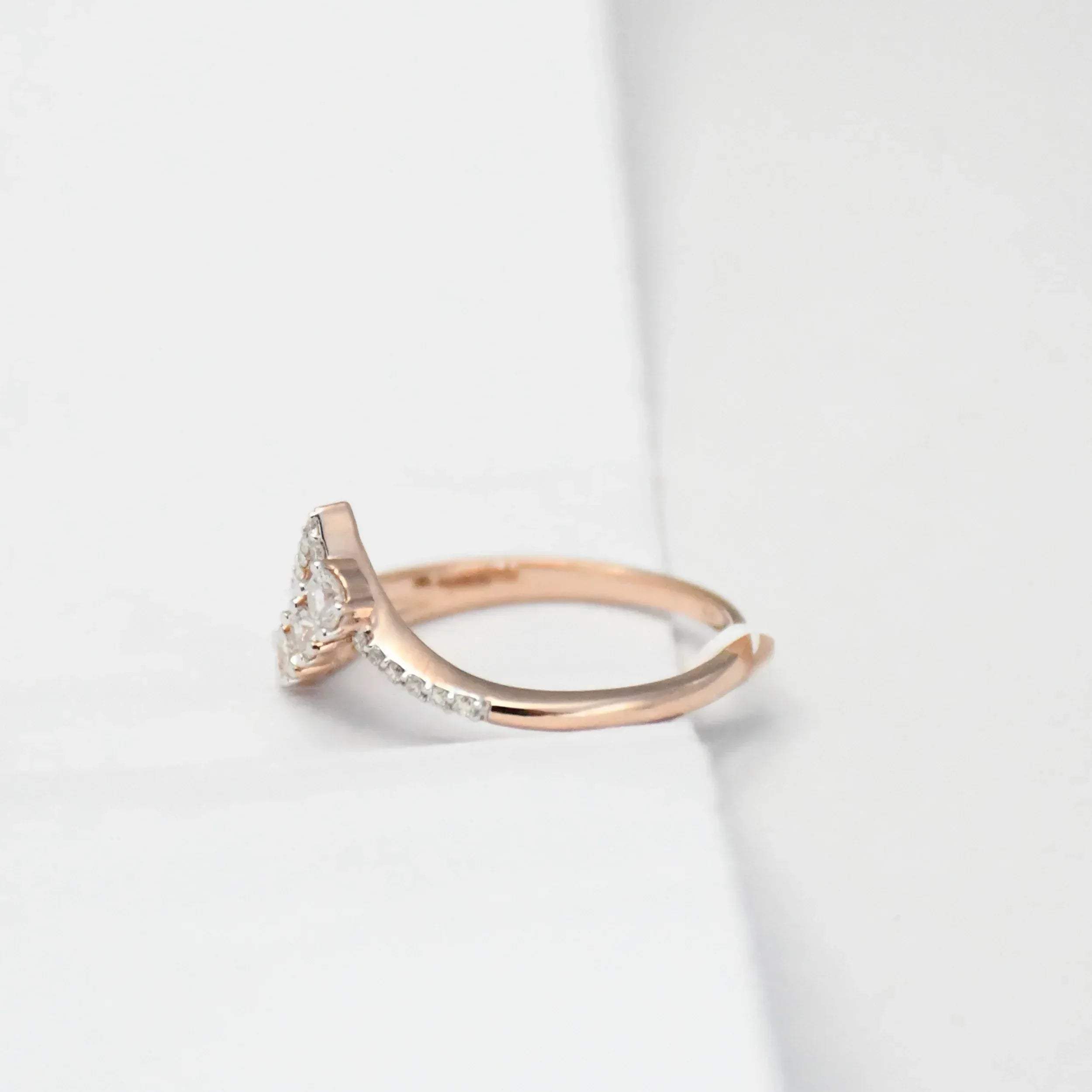 Rose gold ring with diamonds on a light gray background