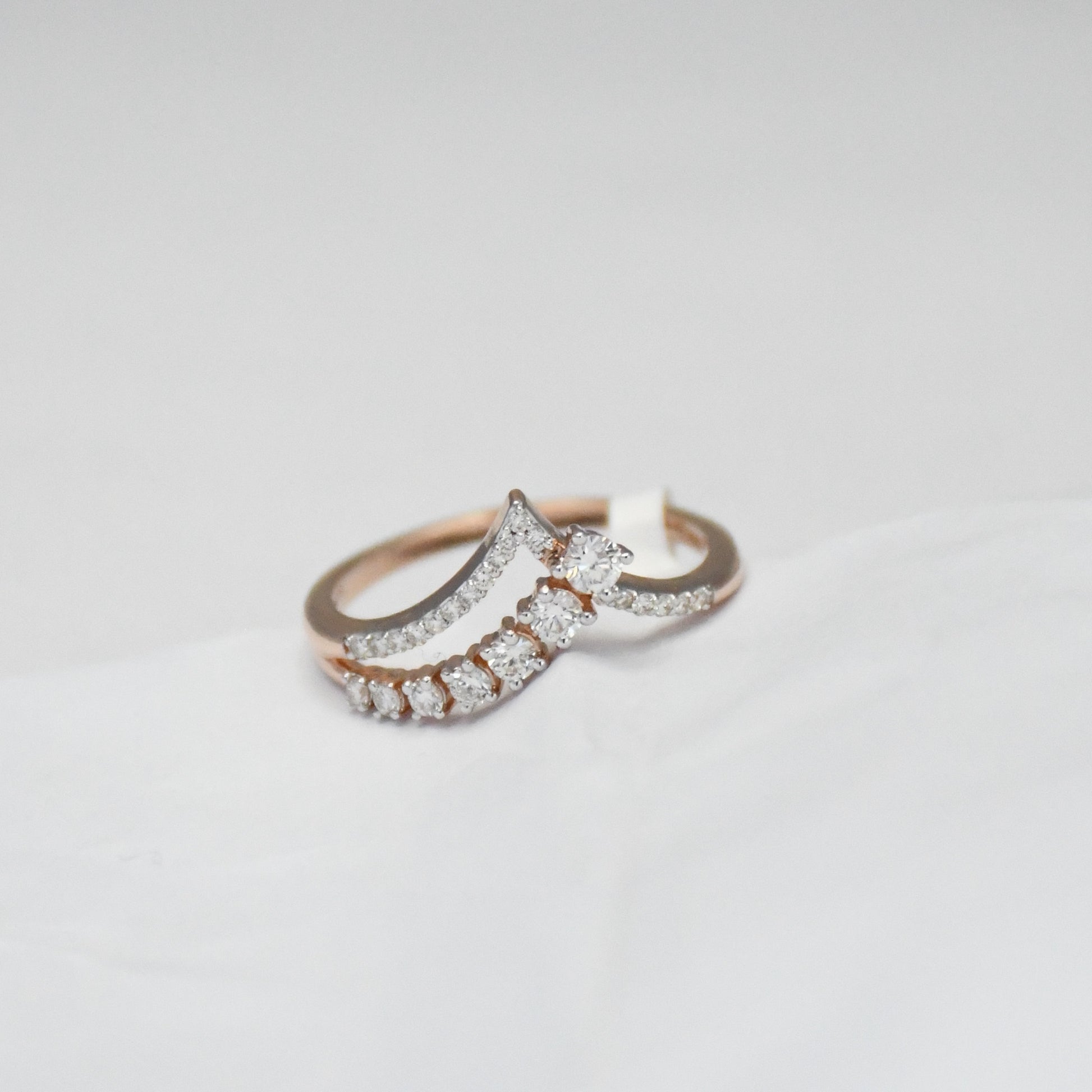 gold diamond ring on a light gray background