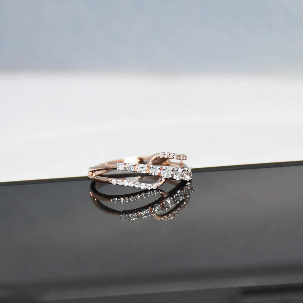 gold ring with diamonds on a reflective surface