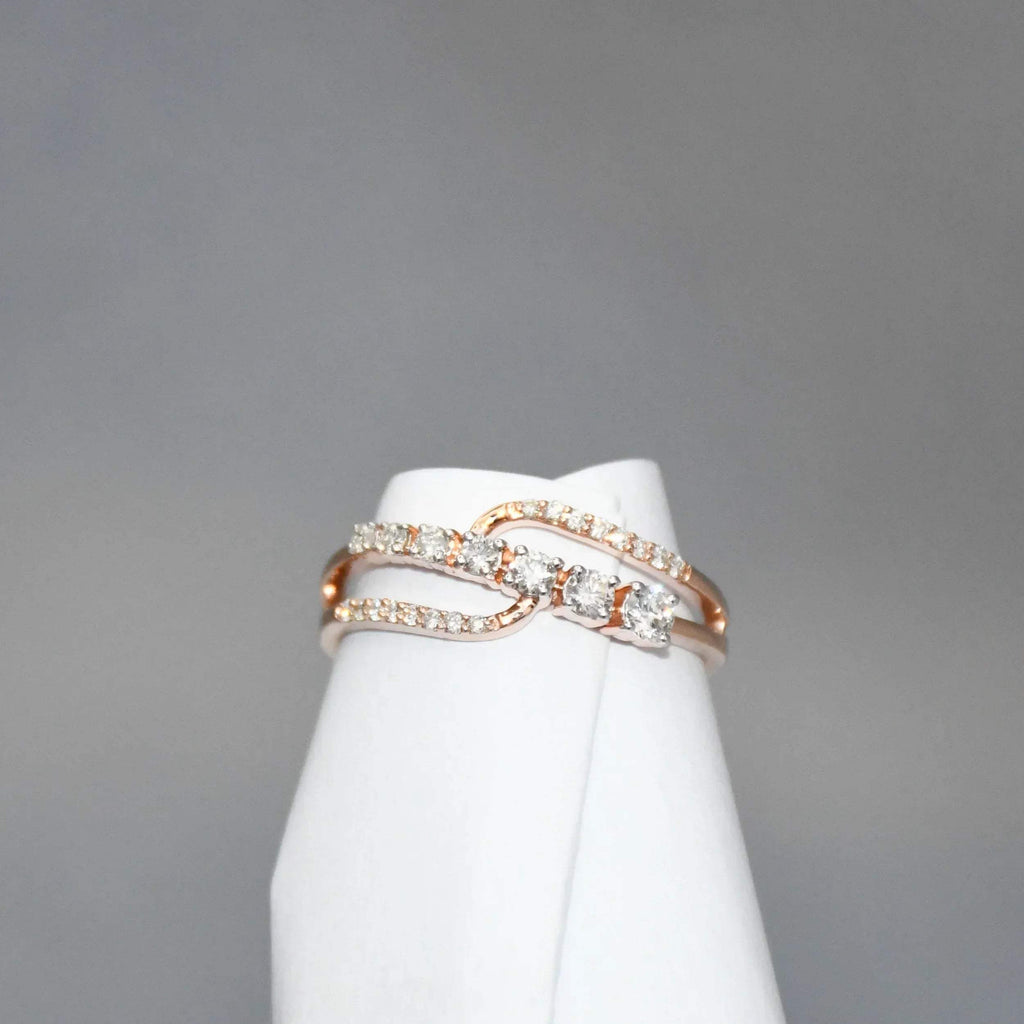 gold ring with diamonds on a white stand against a gray background