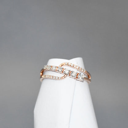 gold ring with diamonds on a white stand against a gray background
