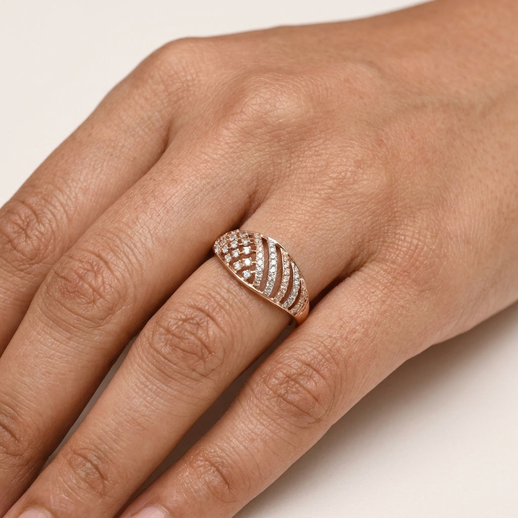 A close-up of a hand wearing a rose gold ring with pavé-set clear diamonds, including a heart-shaped center stone and curved bands.