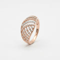 A rose gold ring featuring a curved, leaf-like design paved with small clear diamonds, set against a plain white background.