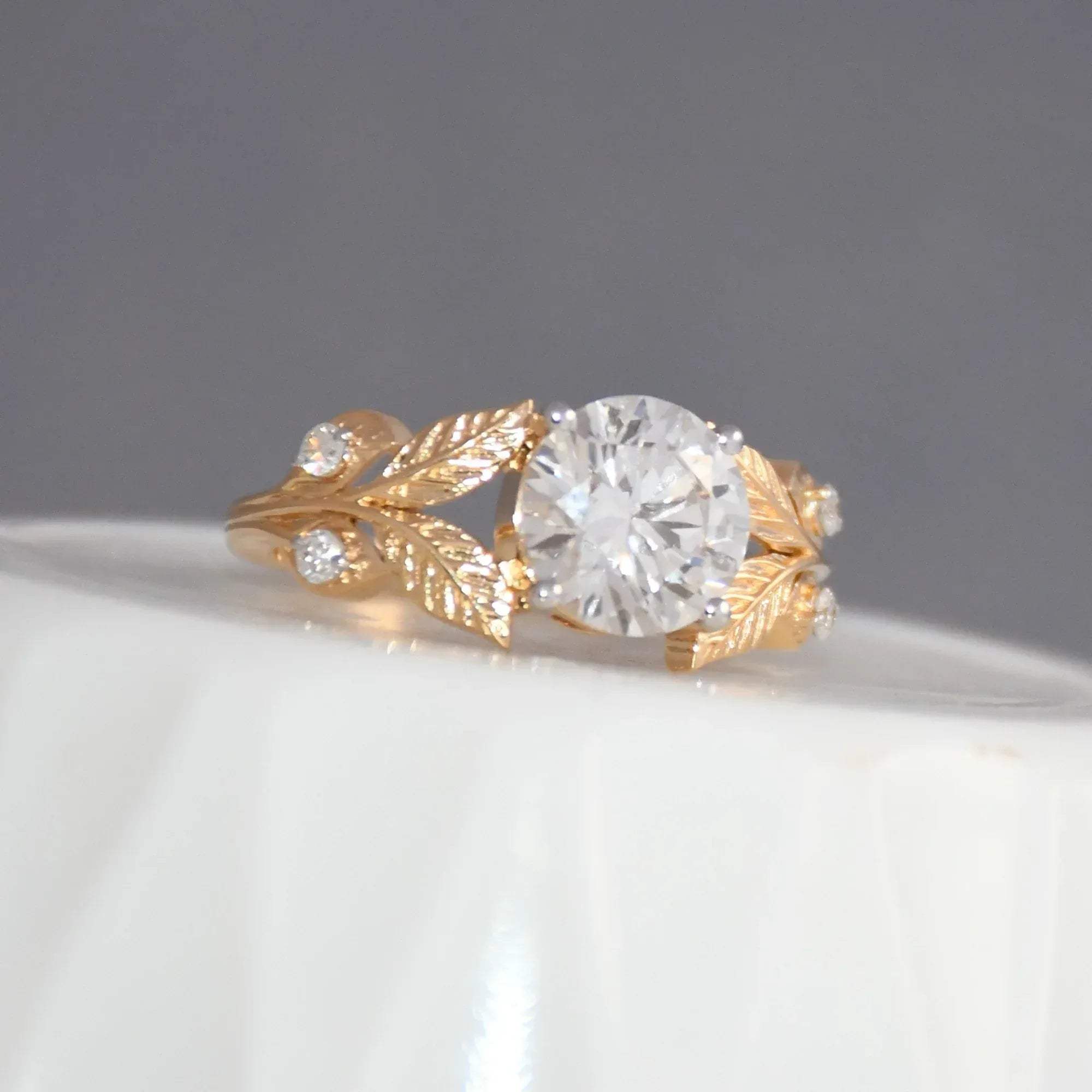 Gold ring with diamond on a gray background.