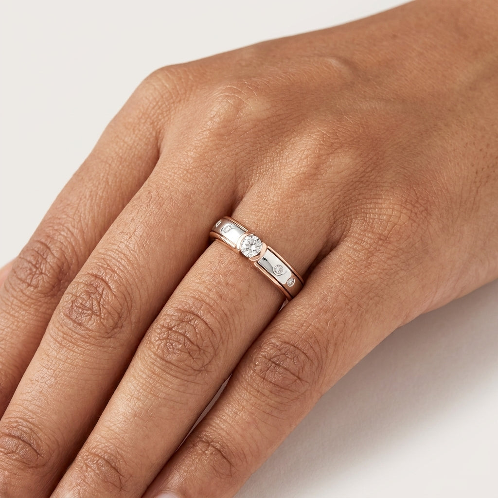 Close-up of a solitaire diamond ring with a combination of white and rose gold bands, featuring brilliant cut diamonds worn in hand's finger.