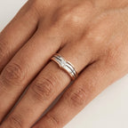 Two-tone gold ring with solitaire diamond worn in a hand's finger.