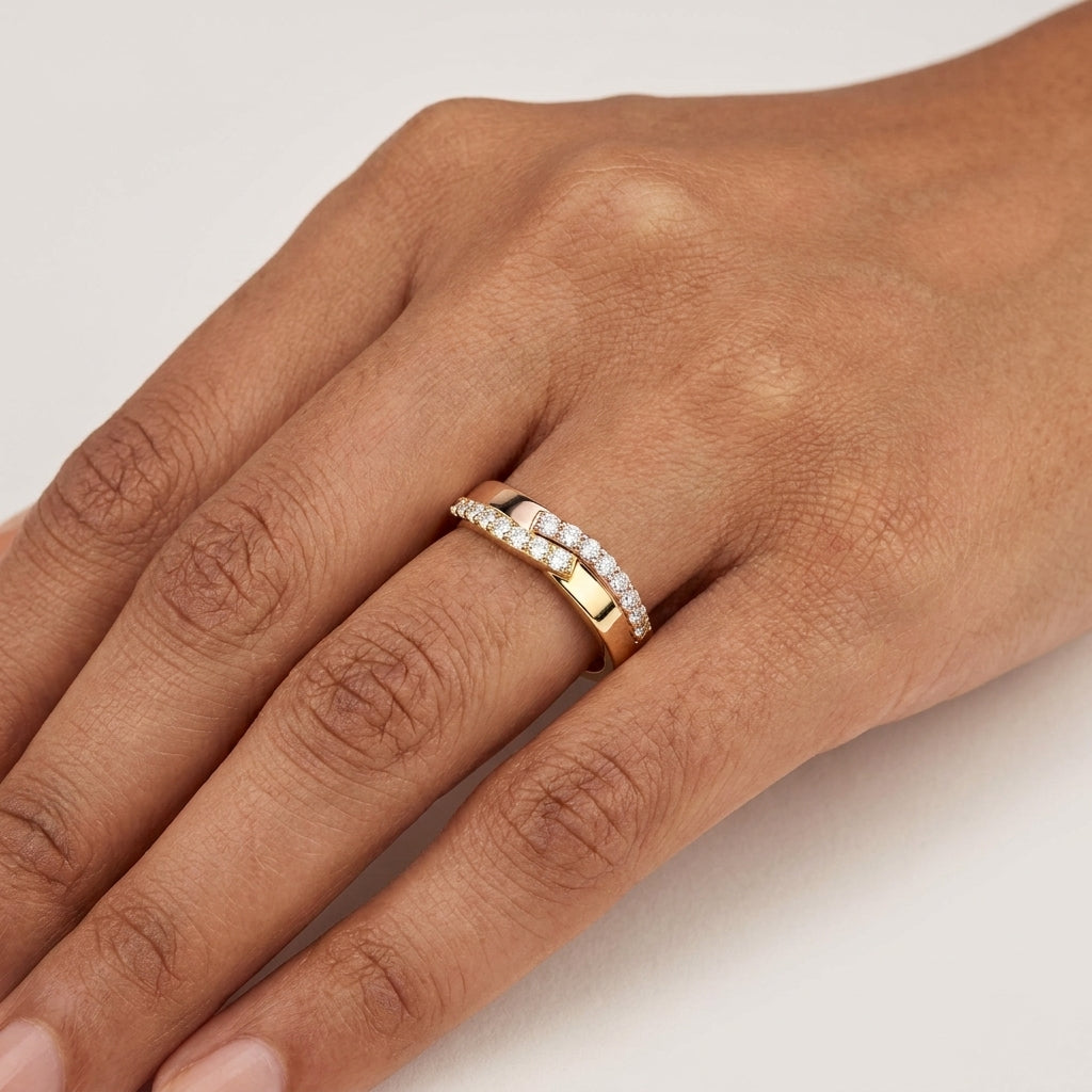 A two-tone gold diamond ring with alternating yellow and rose gold bands, set with multiple round-cut diamonds shown from the close-up worn in a hand's finger.