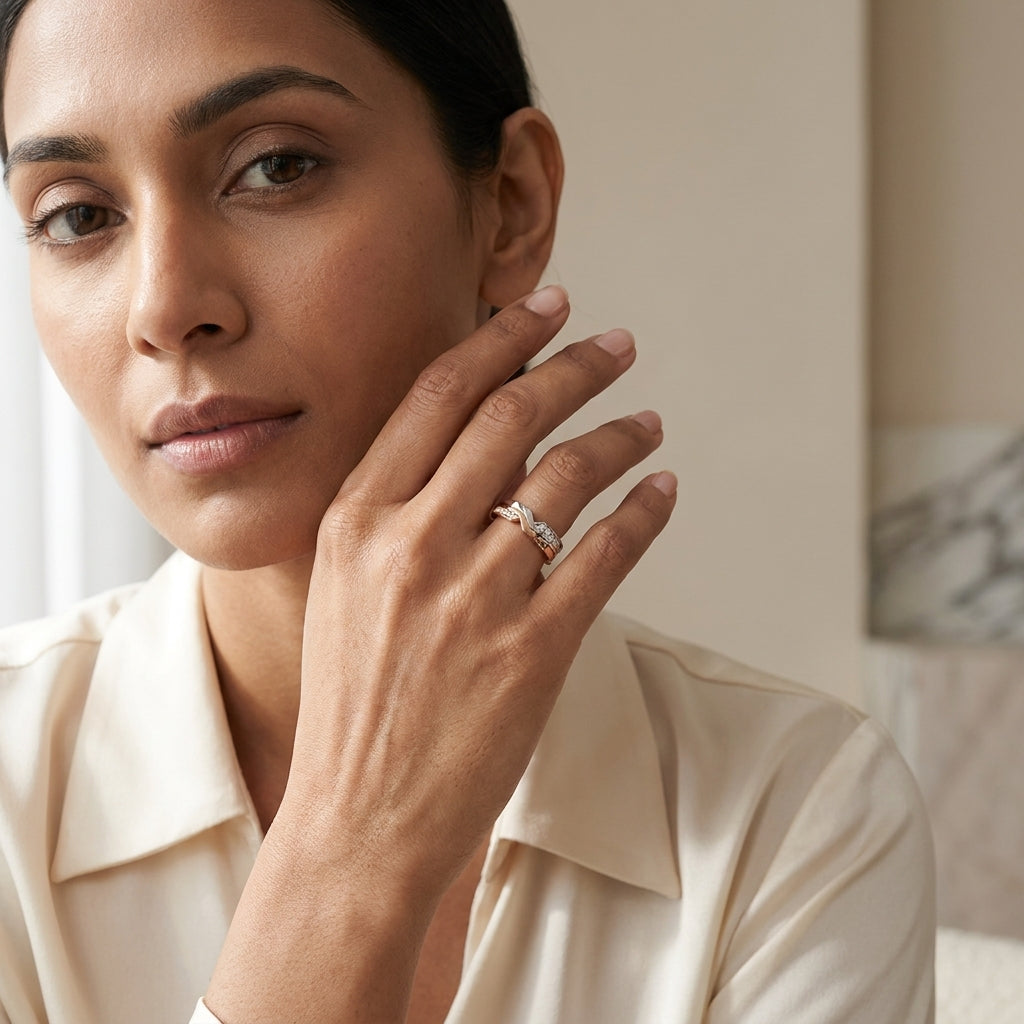 Two-tone ring with diamonds worn by a woman and showing against a neutral background.