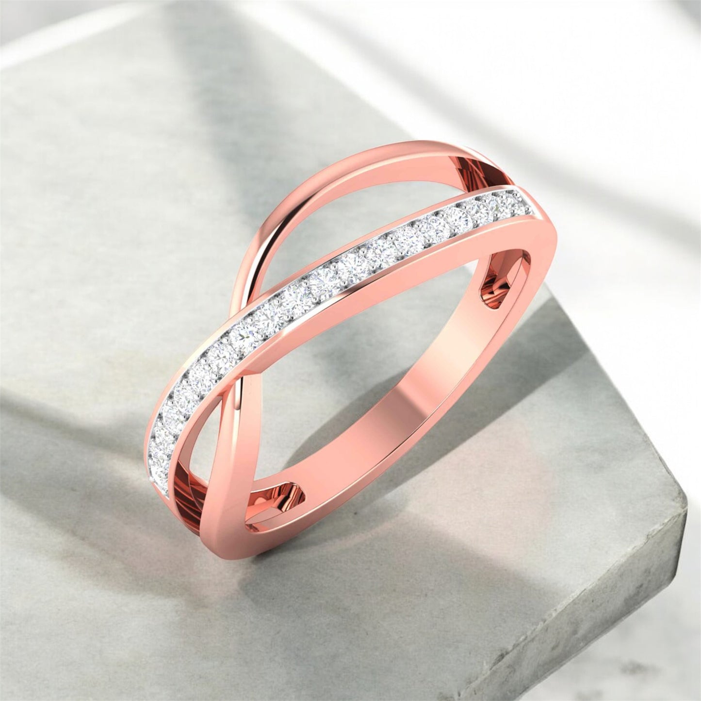 Rose gold ring with diamond accents on a light gray surface