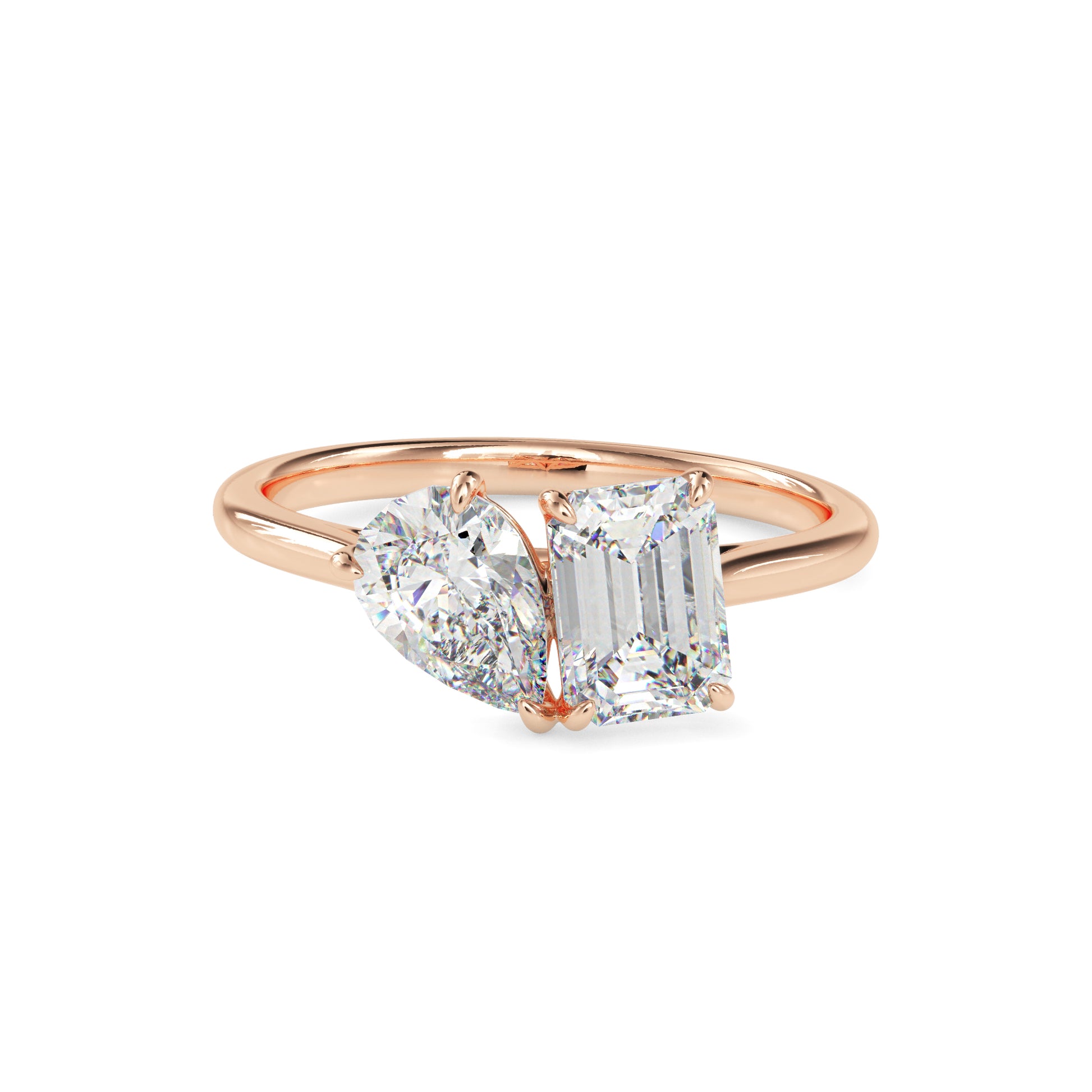Rose gold ring with a emerald-cut and a pear cut diamonds on a white background