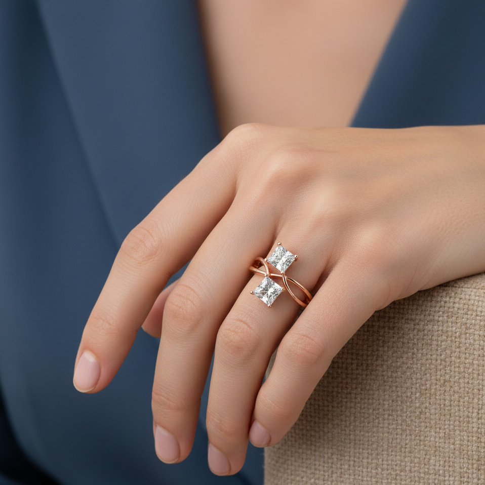 Hand wearing a rose gold ring with princess cut real diamonds against a neutral background