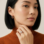 Woman wearing a ring with real diamonds, close-up of face and hand.