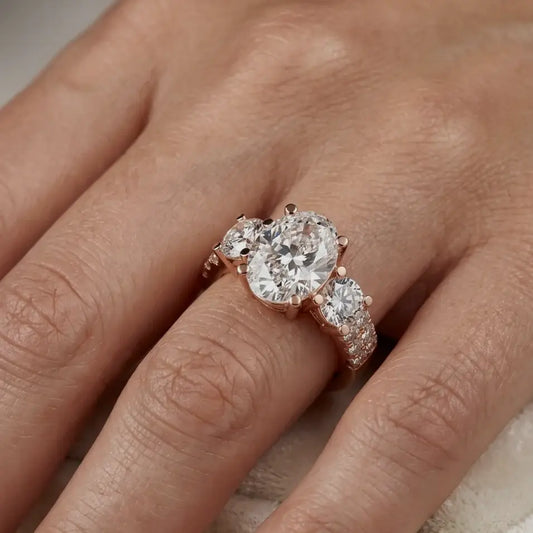 Rose gold ring with three big real diamonds and some small real diamonds on a hand.