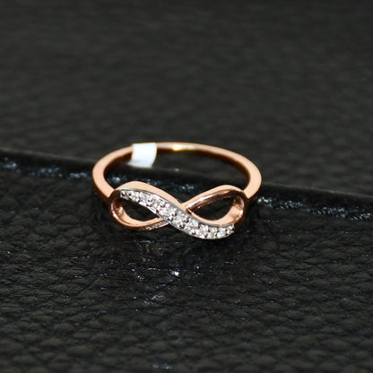 A 14K gold diamond band ring with a infinity shaped inset showing the diamond's cut and color, displayed on a black leather surface.