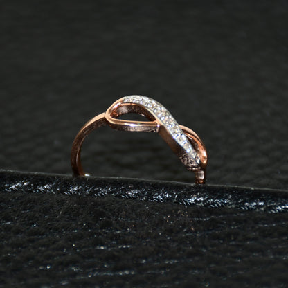 A 14K gold diamond band ring with a infinity shaped inset showing the diamond's cut and color, displayed on a black leather surface.