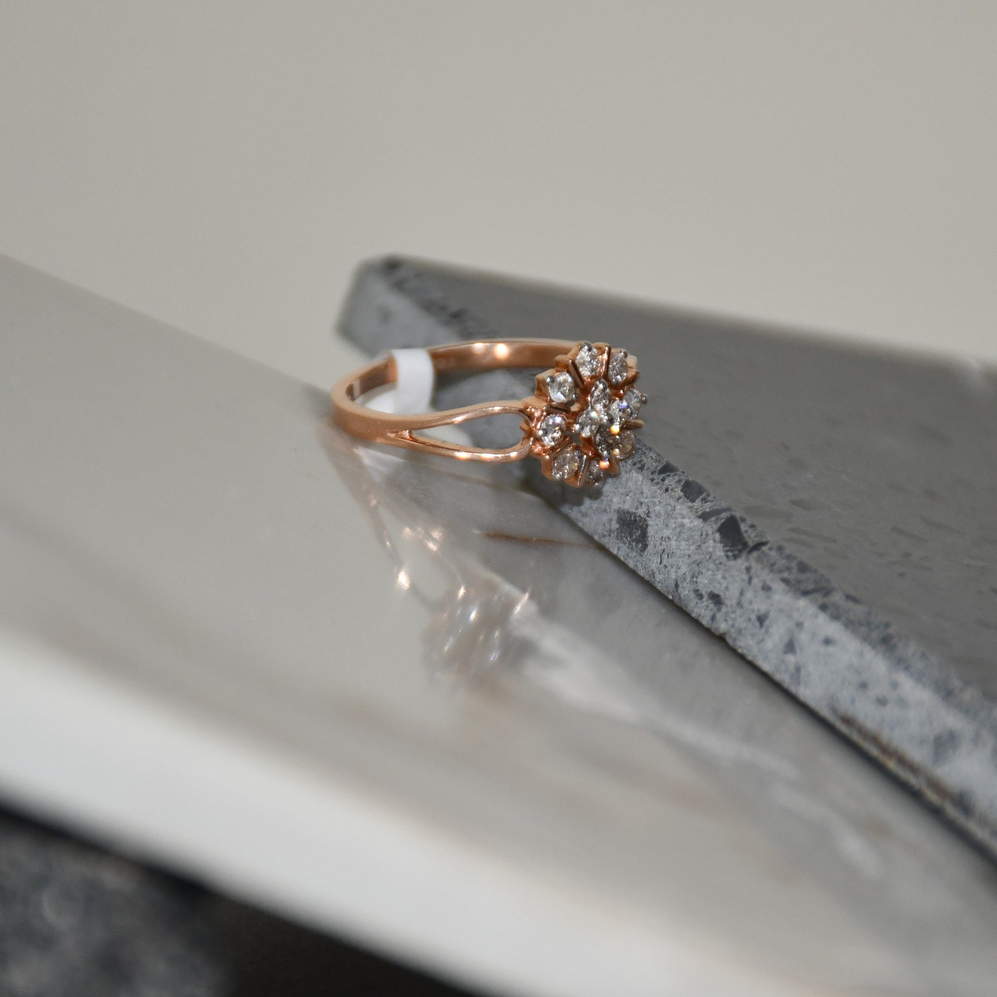 A 14kt gold band ring with a round brilliant cut diamond centerpiece, set on polished and unpolished stones.