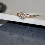 A 14kt gold band ring with a round brilliant cut diamond centerpiece, set on a white surface.
