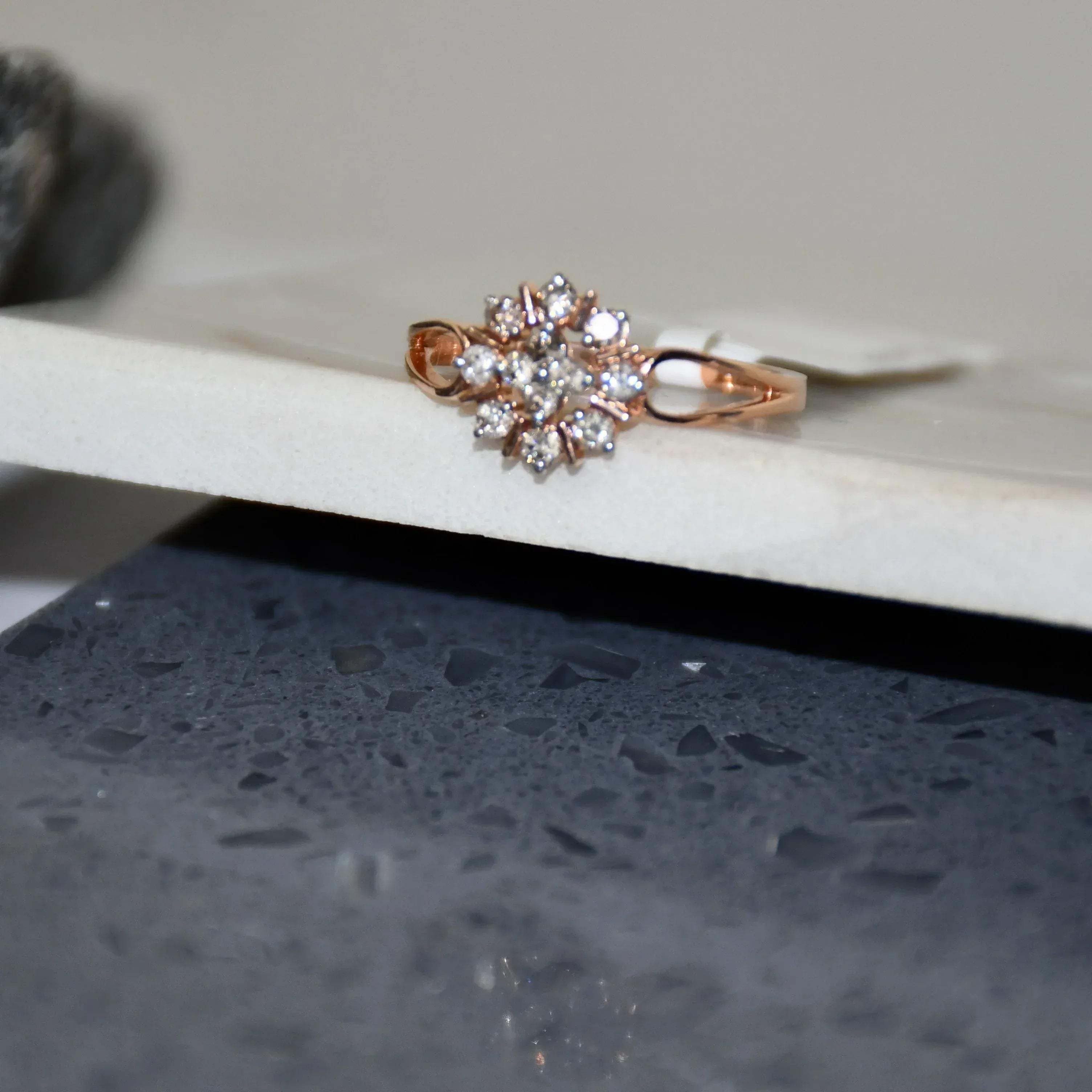 A 14kt gold band ring with a round brilliant cut diamond centerpiece, set on a white surface.