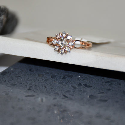 A 14kt gold band ring with a round brilliant cut diamond centerpiece, set on a white surface.