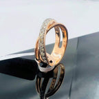 A diamond band ring with 14K gold hallmark, displayed on black reflective surface.