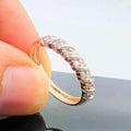 A person's hand holding a 14K gold hallmark ring with certified diamonds set around its circumference.