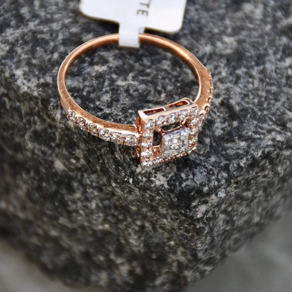 A 14K gold ring with a central square-shaped setting holding a sparkling, multicolored diamond, surrounded by smaller round diamonds set in a rough and textured surface.