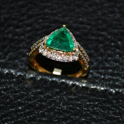 A green semi-precious stone ring with a 14KT gold band and brilliant cut diamonds on the top and bottom is displayed on a black leathered surface.