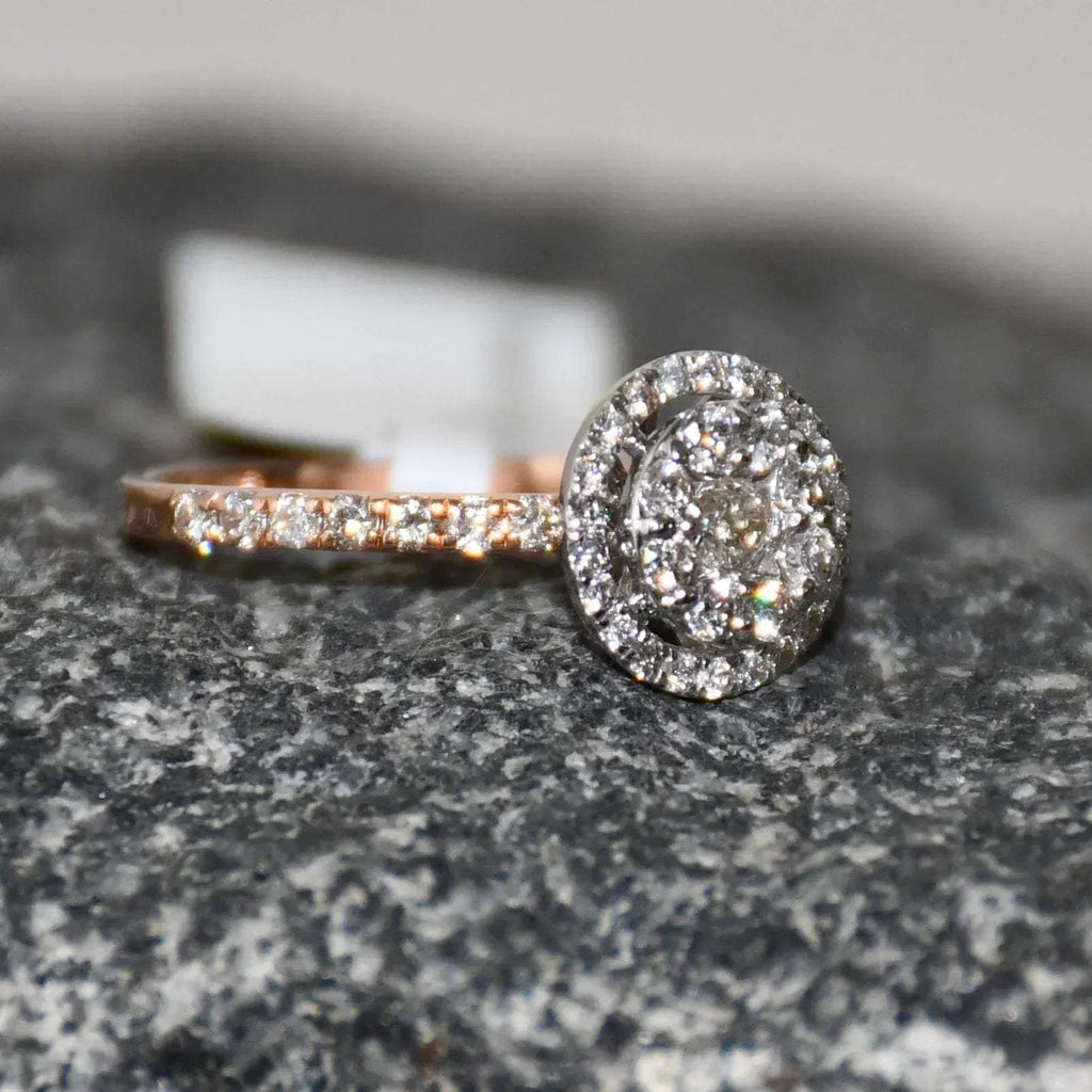 A diamond ring is displayed on a rough and textured surface.